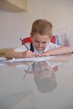 young mom woman doing home work with elementary school grade boy at home in kitchen