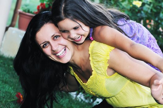 beautiful mom and daughter outdoor in garden  together with flower have fun and hug 