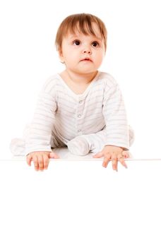 Cute baby sitting on the white floor background with space for text. Isolated.