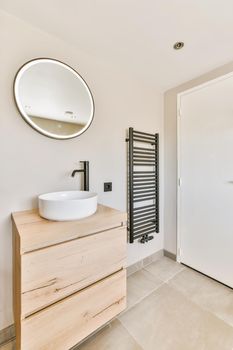 Delightful minimalist bathroom with illuminated round mirror