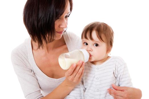 Teenage mother feeding her newborn baby with the bottle. Isolsted on white.