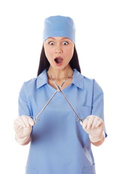 Full isolated studio picture from a young female doctor holding medicine scissors and looking scared.