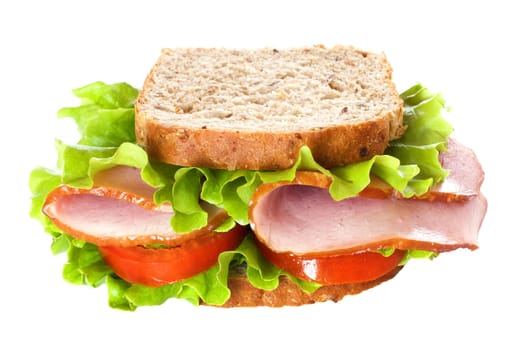 Big healthy sandwich with wholewheat bread, ham, tomatoes and curly lettuce, isolated on white.