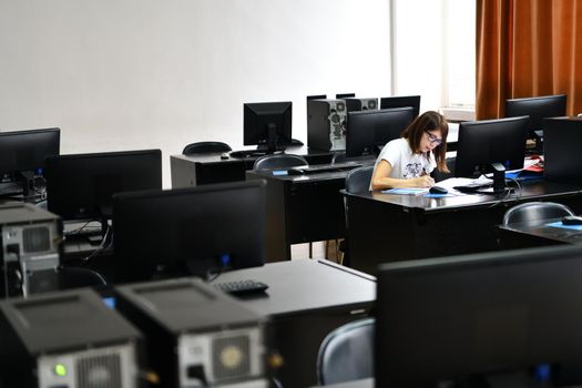 Only one female student in computers and  technology classroom working and learning concept of persistence