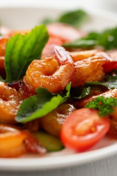 Close-up of fresh shrimp, tomato, arugula and greens salad, vertical image.