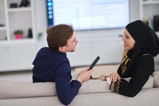 Young muslim couple enjoing time together at home during Ramadan. Happy arabic family watching TV