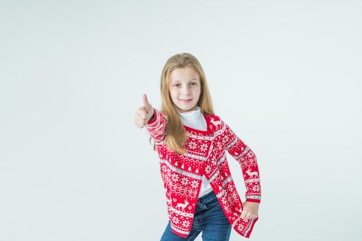 Photo portrait of kid dancing keeping hands up over head wearing red christmas sweater isolated on blue color background