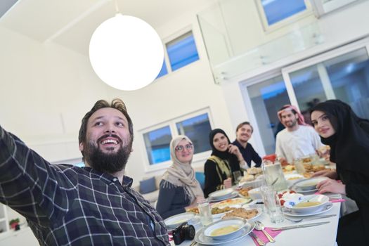 Muslim family taking selfie while having iftar together during Ramadan. Arabian people gathering for traditional dinner during fasting month.