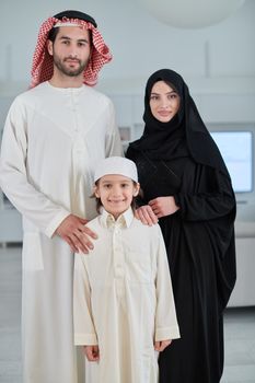 Portrait of young arabian muslim family wearing traditional clothes at their modern house spending time together during Ramadan