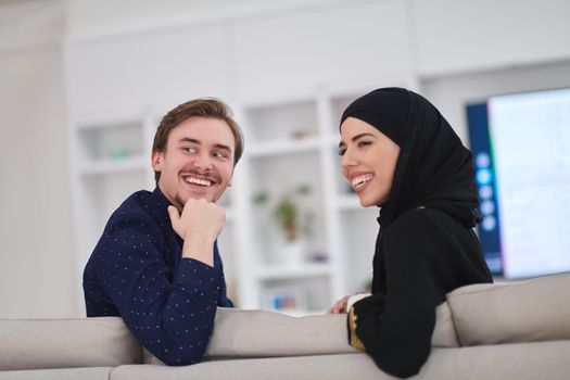 Young muslim couple enjoing time together at home during Ramadan. Happy arabic family watching TV