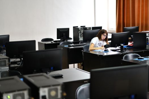 Only one female student in computers and  technology classroom working and learning concept of persistence