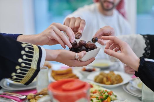 Muslim family having iftar together during Ramadan. Arabian people gathering for traditional dinner during fasting month. Dates sharing to break fasting