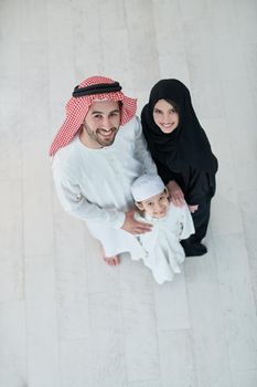 Top view of young arabian muslim family wearing traditional clothes at their modern house spending time together during Ramadan