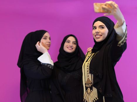 Portrait of Arab women wearing traditional clothes or abaya. Young muslim girls taking selfie representing islamic arabic fashion and ramadan kareem concept