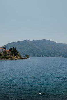 Blue boat in Bay of Kotor of Adriatic Sea, Montenegro. Beautiful view of the natural landscape. shore of Kotor. Scenic summer resort landscape. summer rest, vacation.