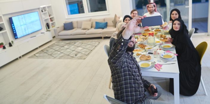 Muslim family taking selfie while having iftar together during Ramadan. Arabian people gathering for traditional dinner during fasting month.