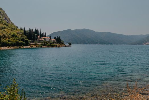 Blue boat in Bay of Kotor of Adriatic Sea, Montenegro. Beautiful view of the natural landscape. shore of Kotor. Scenic summer resort landscape. summer rest, vacation.