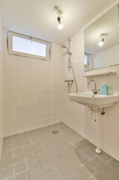 Sink with tap and liquid soap under mirror in contemporary restroom at home