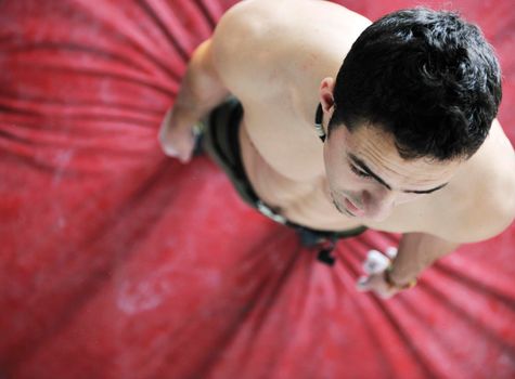 young and fit man exercise free mountain climbing on indoor practice wall