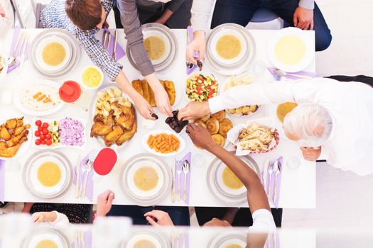 top view of modern multiethnic muslim family enjoying eating iftar dinner together during a ramadan feast at home