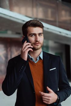 businessman architect expert using a smartphone while overseeing the construction site of a modern office building