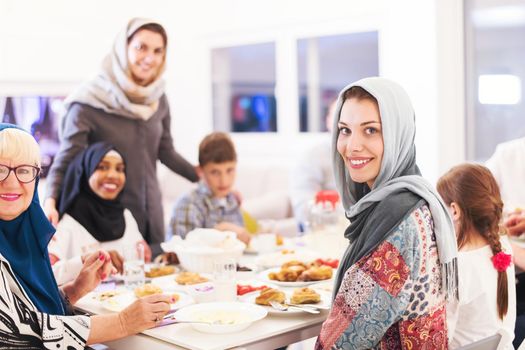 young modern muslim woman enjoying iftar dinner together with multiethnic family during a ramadan feast at home