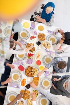 top view of modern multiethnic muslim family enjoying eating iftar dinner together during a ramadan feast at home