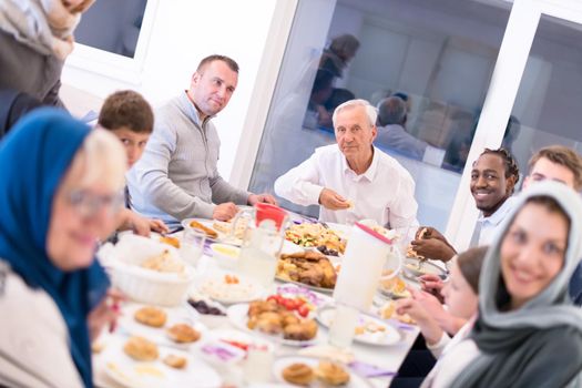 modern multiethnic muslim family enjoying eating iftar dinner together during a ramadan feast at home