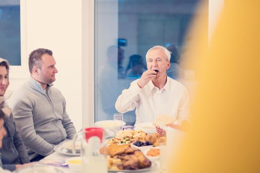 modern multiethnic muslim family enjoying eating iftar dinner together during a ramadan feast at home