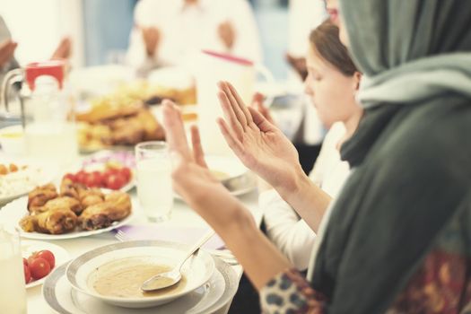 modern multiethnic muslim family praying before having iftar dinner together during a ramadan feast at home