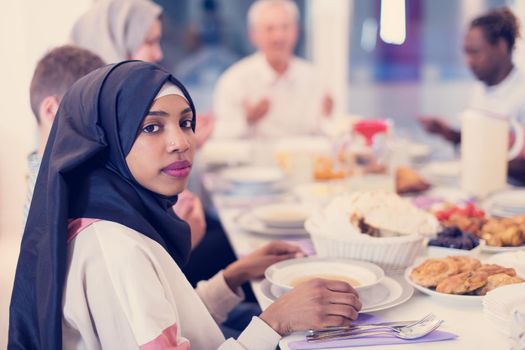 modern african american muslim woman enjoying iftar dinner together with multiethnic family during a ramadan feast at home