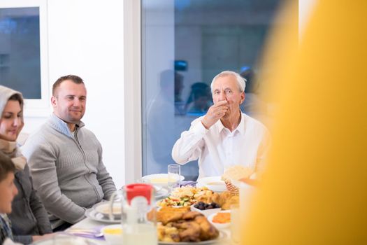 modern multiethnic muslim family enjoying eating iftar dinner together during a ramadan feast at home