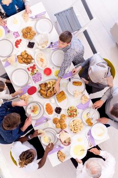 top view of modern multiethnic muslim family enjoying eating iftar dinner together during a ramadan feast at home