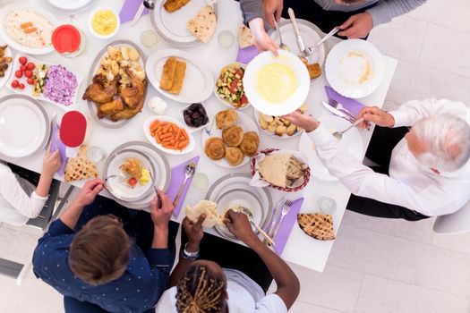 top view of modern multiethnic muslim family enjoying eating iftar dinner together during a ramadan feast at home