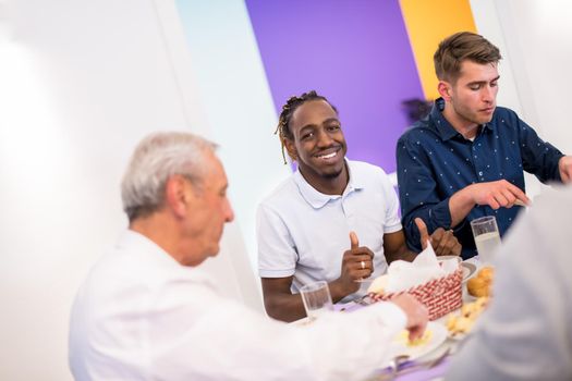 african american man enjoying iftar dinner together with modern multiethnic muslim family during a ramadan feast at home