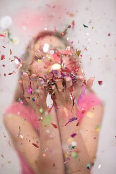 Beautiful  woman blowing confetti in the air party new years eve celebration isolated on white background