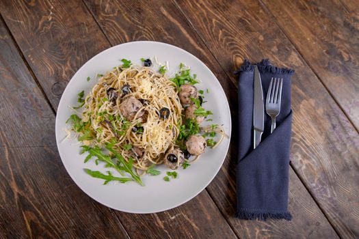 Spaghetti with meatballs and tomato sauce, italian pasta with olives and arugula