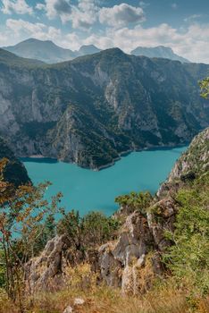 The concept of eco-tourism and active recreation. National Park. Mountain Emerald lake in the wooded mountains. Sunny day in autumn.