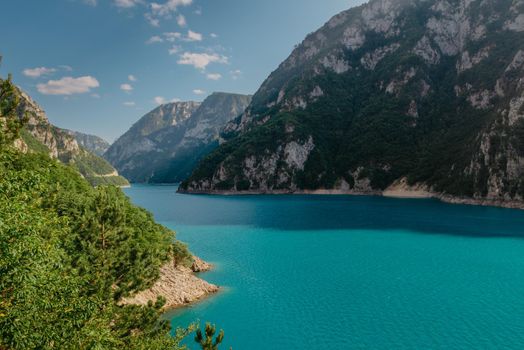 The concept of eco-tourism and active recreation. National Park. Mountain Emerald lake in the wooded mountains. Sunny day in autumn.