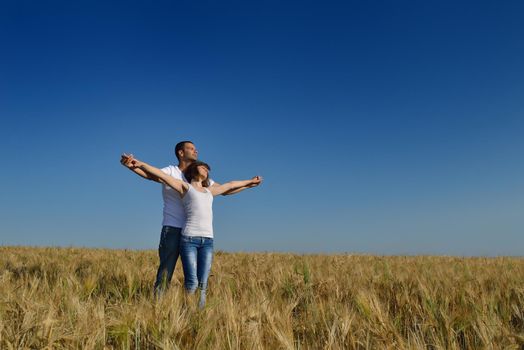 happy young couple in love have romance and fun at wheat field in summer