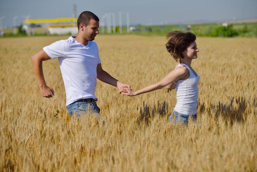 happy young couple in love have romance and fun at wheat field in summer