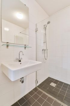 Stylish bathroom with brown tiled floor and glass-enclosed walk-in shower