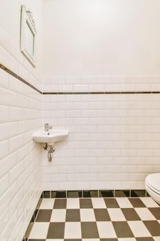 Small restroom with black and white checkerboard floor