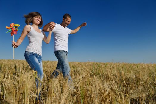 happy young couple in love have romance and fun at wheat field in summer