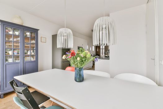 Stylish dining area with a chic chandelier and a vase of flowers on the table