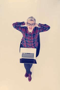 top view of young business woman working on laptop computer in modern bright startup office interior, sitting on floor