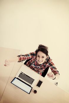 top view of young business woman working on laptop computer in modern bright startup office interior