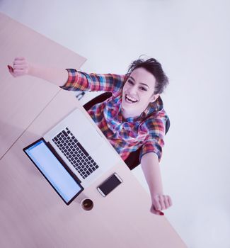 top view of young business woman working on laptop computer in modern bright startup office interior