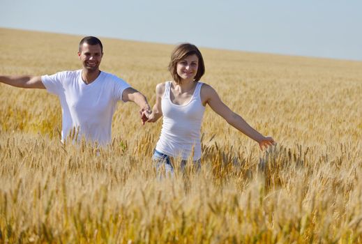 happy young couple in love have romance and fun at wheat field in summer