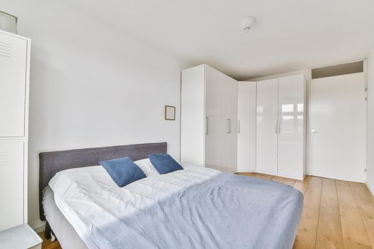 Stylish bedroom with a beautifully laid bed and a large white wardrobe